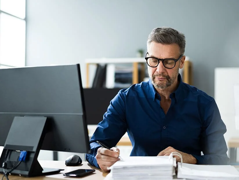 middle aged man reading a large binder 1.webp