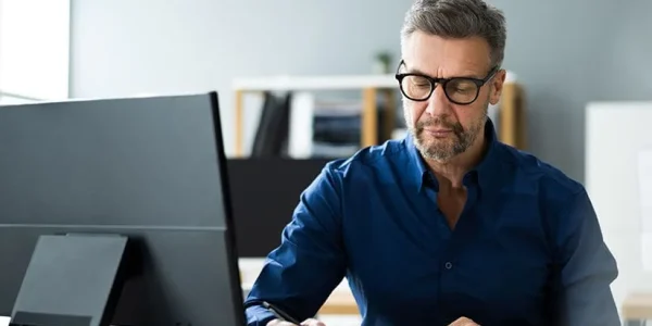 middle aged man reading a large binder 1